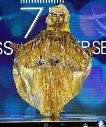 شاهد .. بالصور - ملكة جمال بريطانيا تكرم الملكة إليزابيث وملكة جمال روسيا تدعو للسلام من خلال الزي الذي إختارته