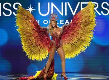 شاهد .. بالصور - ملكة جمال بريطانيا تكرم الملكة إليزابيث وملكة جمال روسيا تدعو للسلام من خلال الزي الذي إختارته