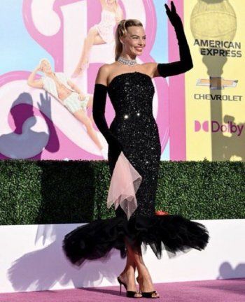 شاهد .. بالصور- مارغو روبي تعيد إحياء باربي الستينيات بفستان لامع بدون حمالات