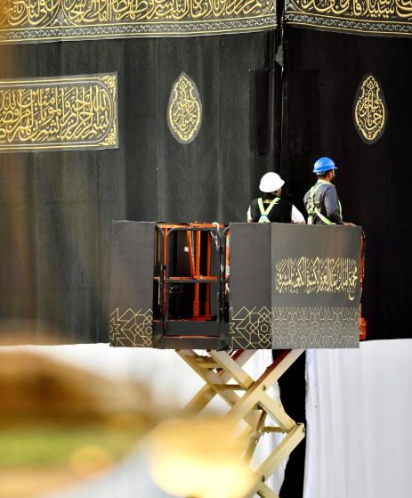 فريق سعودي يشرف على تغيير كسوة الكعبة المشرفة.. صور